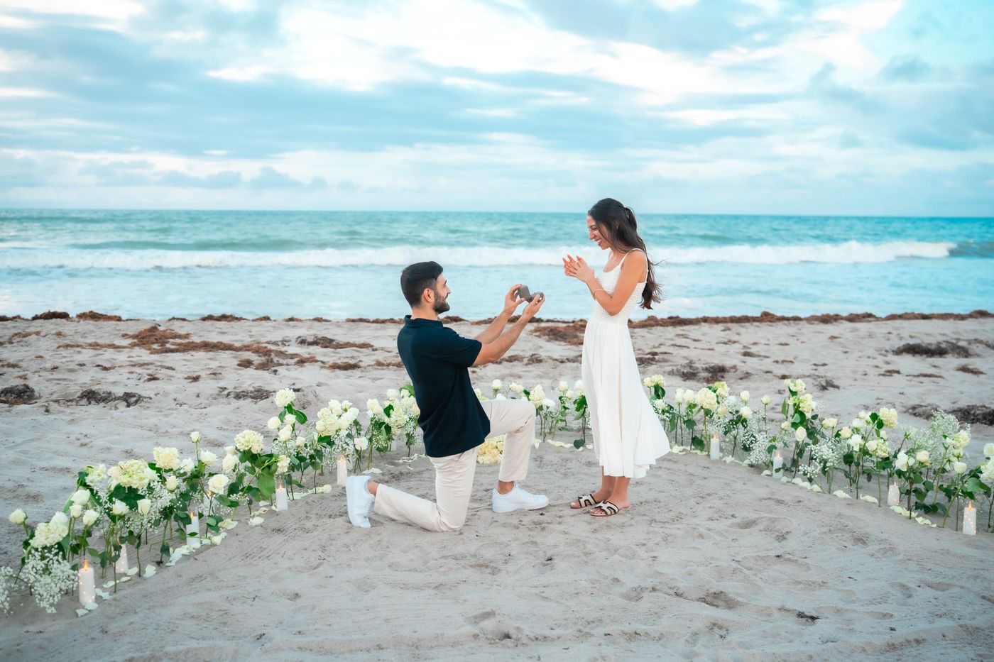 Sahar proposing on one knee on the beach