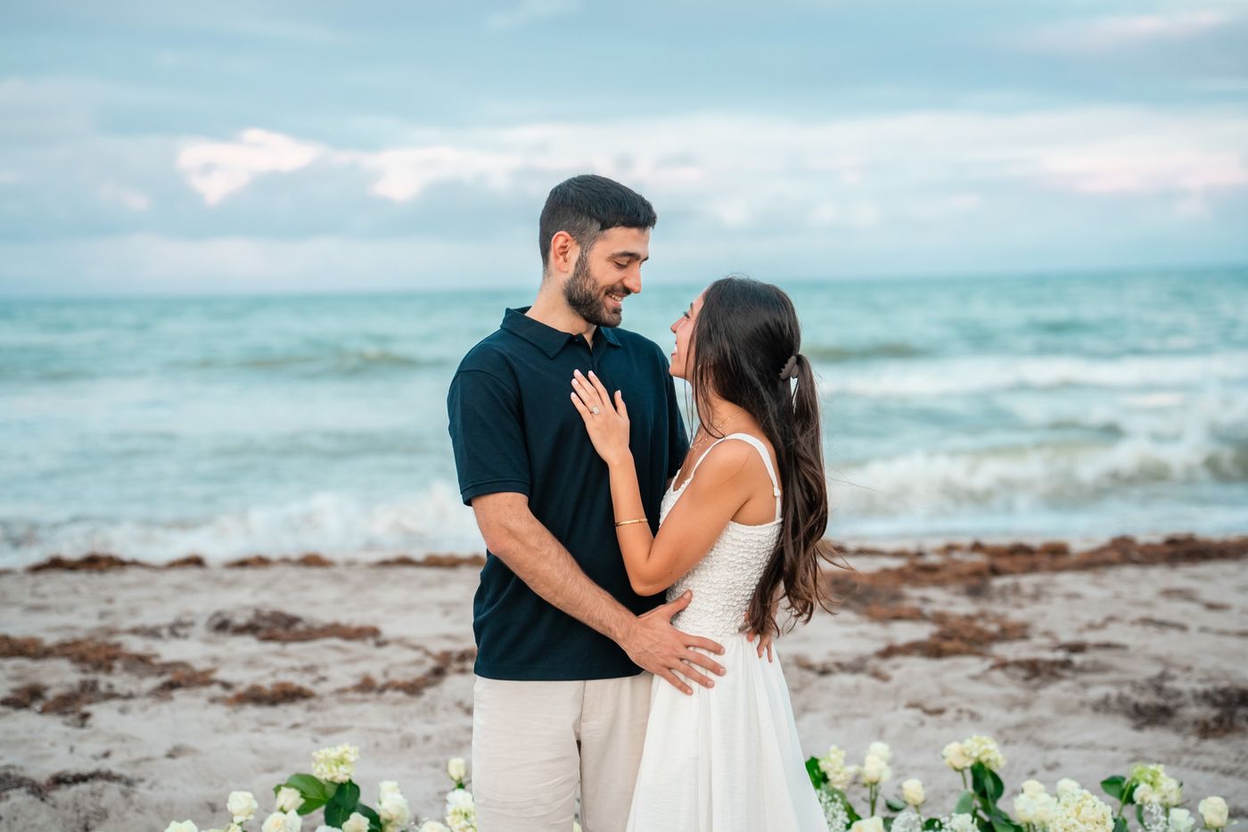 Talya and Sahar smiling at each other by the sea